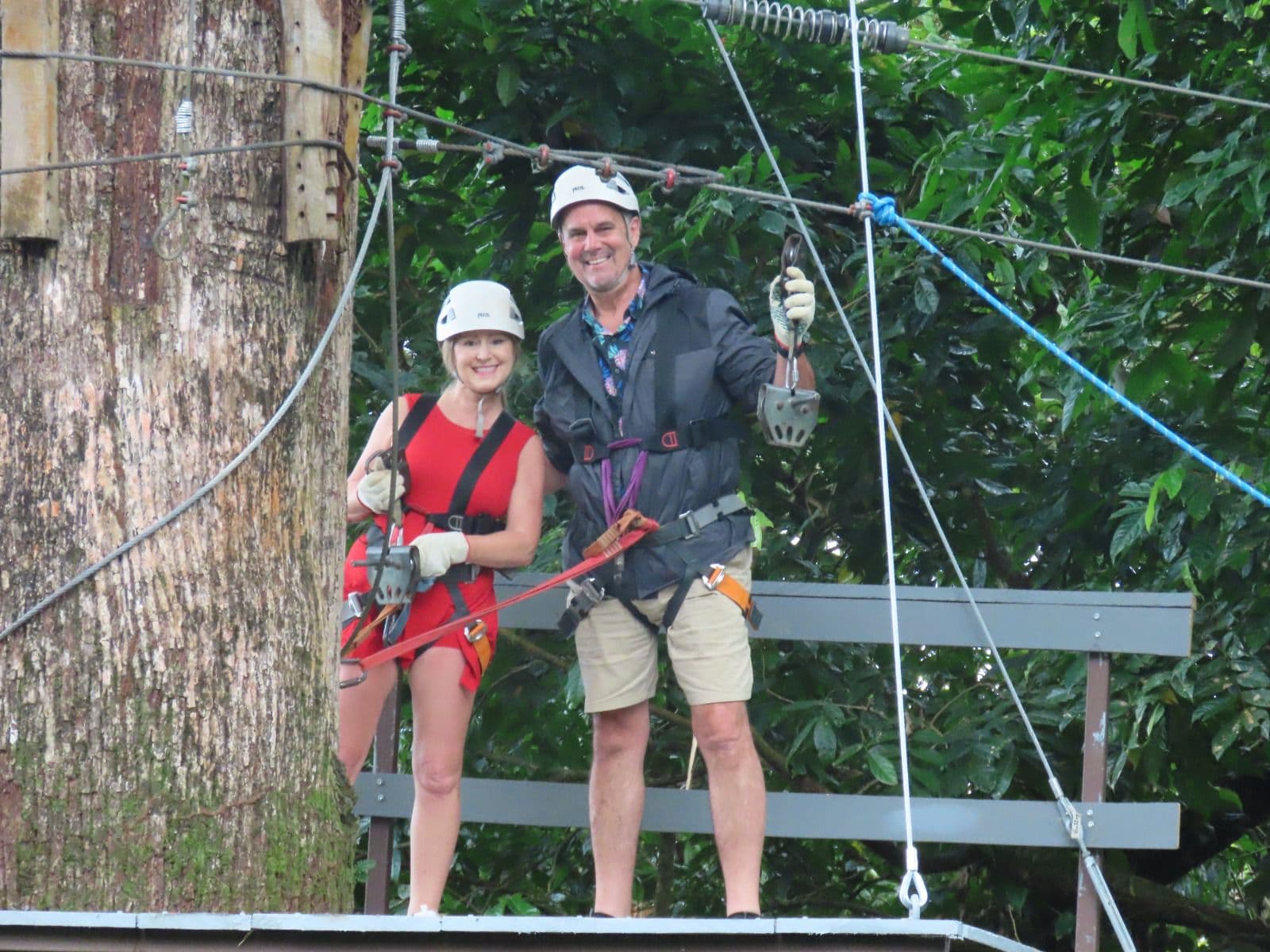 Couple smiling at the zip line platform ready to go